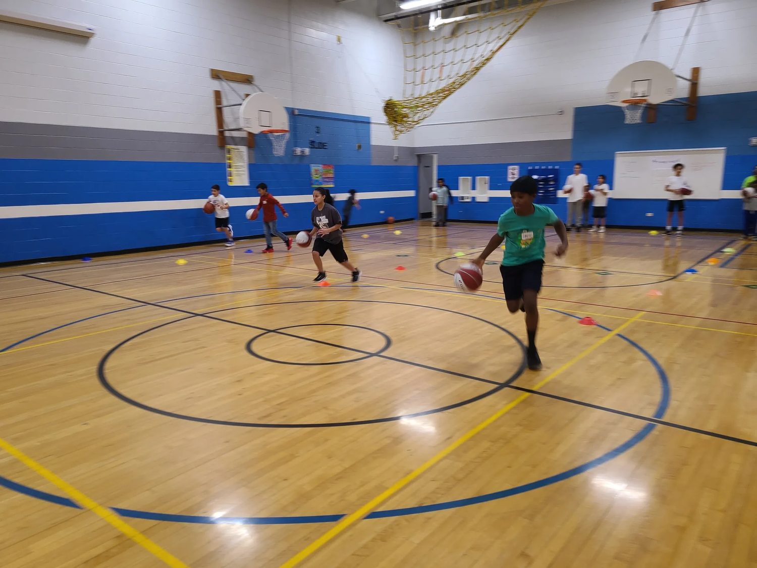 Kids running basketball drills